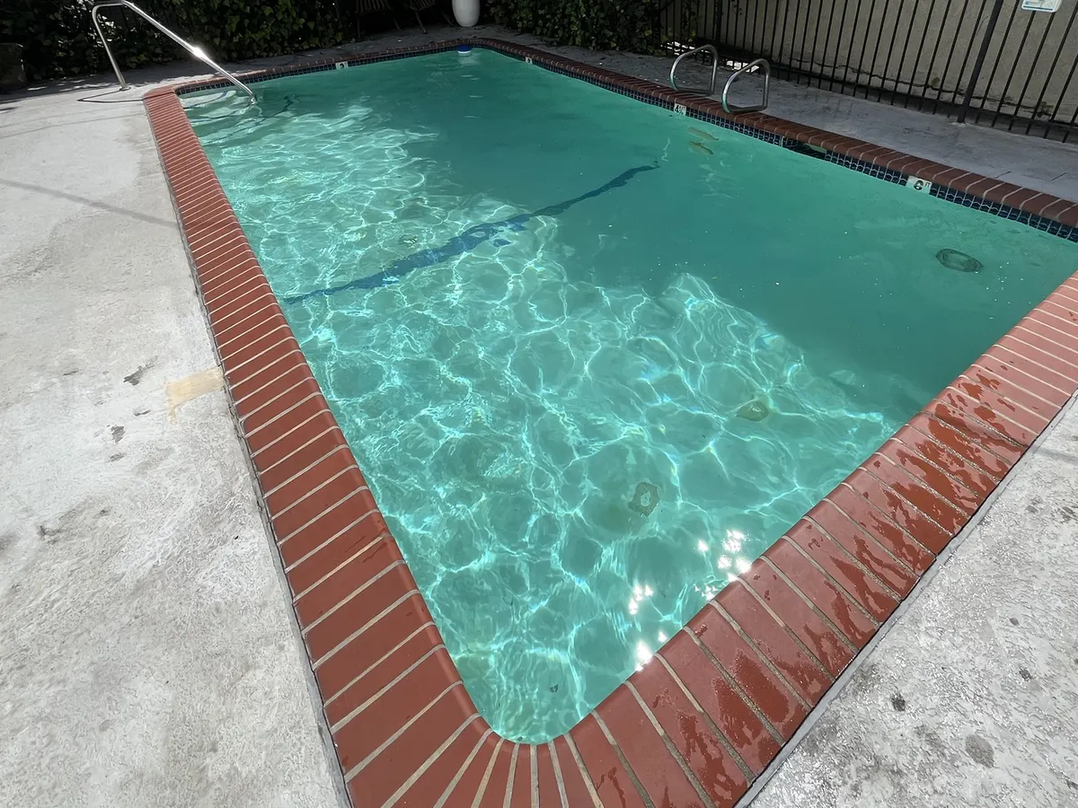 Older Burbank pool with brick coping and worn plaster, a common candidate for renovation