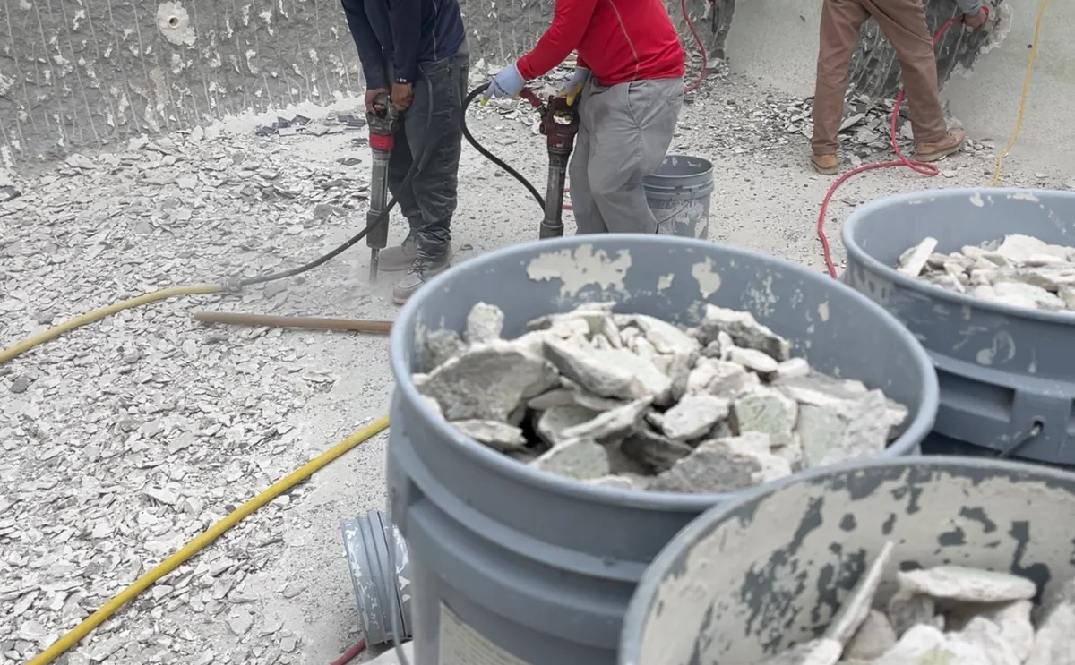 GK Swimming Pools crew removing old plaster during a pool renovation